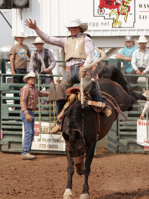A man rides a bucking horse at the 2015 Klickitat County Fair Rodeo.