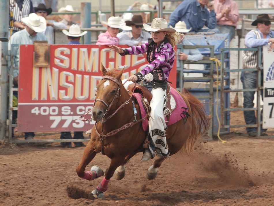 Klickitat County Fair and Rodeo Queen rides her horse and waves to the crowd.