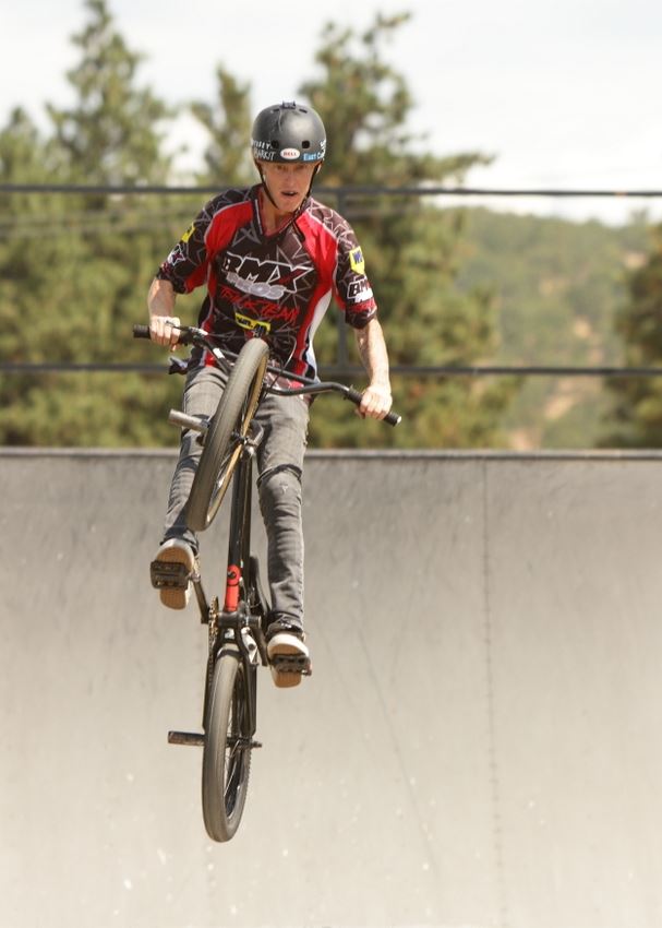 A man does tricks on his BMX bike.