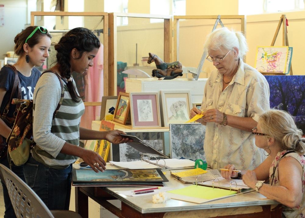 Women discuss art pieces at an exhibit at the 2014 Klickitat County Fair.