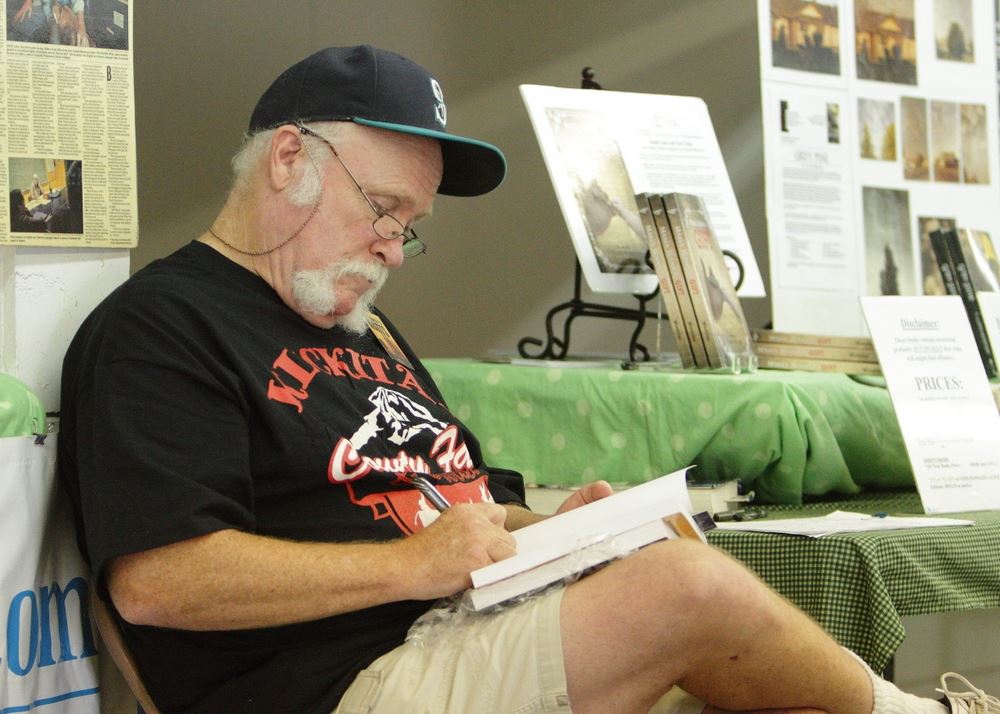 A man writes in a book.