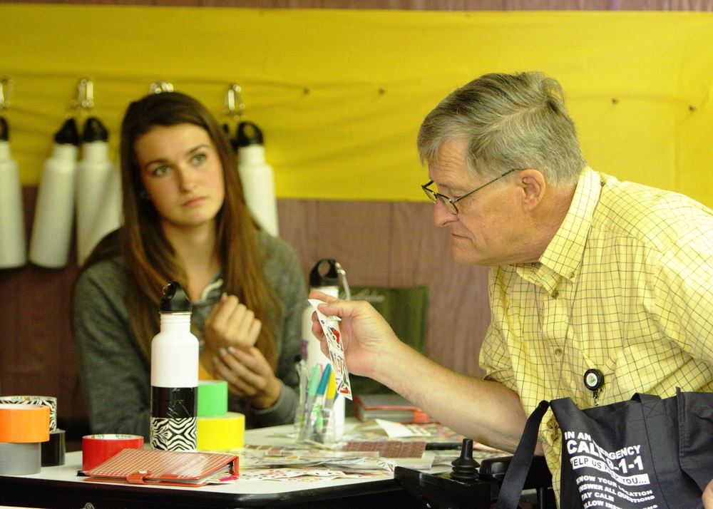 A man looks at stickers at the Waste Reduction exhibit.