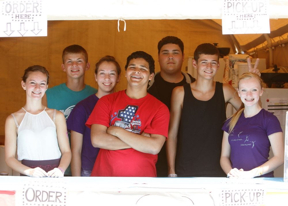 A group of teens stand together at a booth at the 2014 Klickitat County Fair.