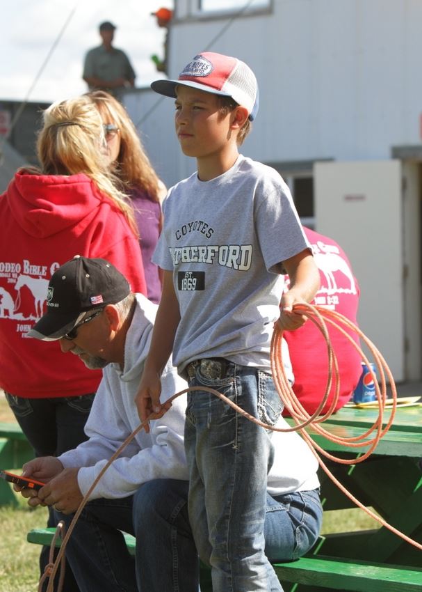 A boy wearing a King Ropes hat works on his lasso.