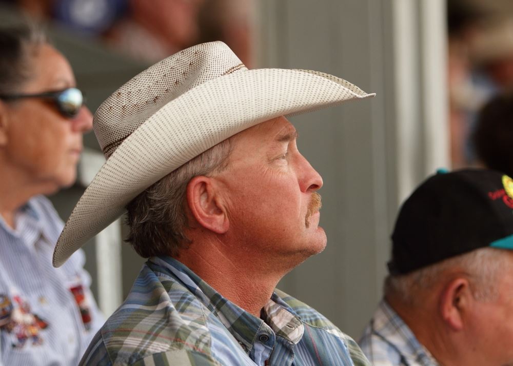 A man in a cowboy hat sits among the crowd at the 2014 Klickitat County Fair.