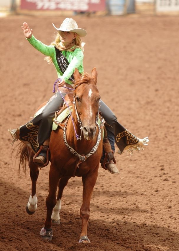 A rodeo queen rides by on her horse and waves to the crowd at the 2014 Klickitat County Fair Rodeo.