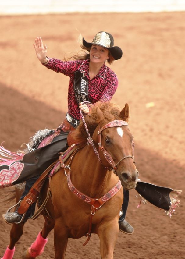 The Alder Creek Rodeo Queen waves as she rides by on her horse at the 2014 Klickitat County Fair Rodeo.