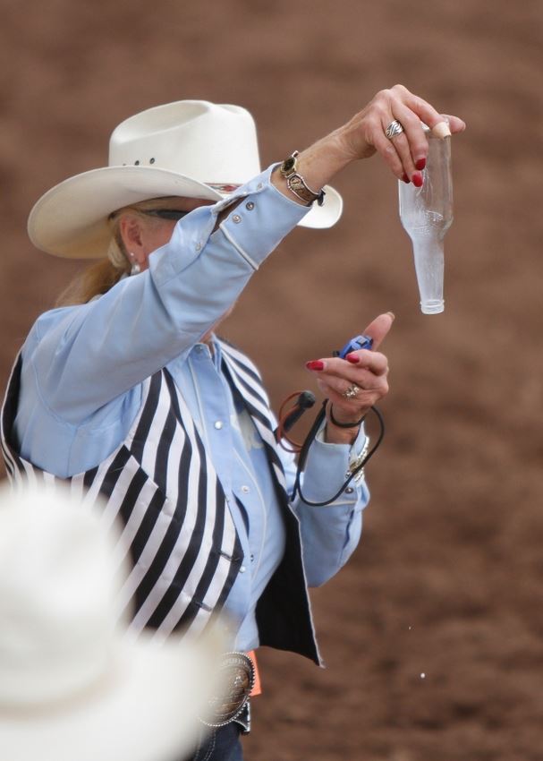 A female judge tips over a glass bottle that was holding milk.