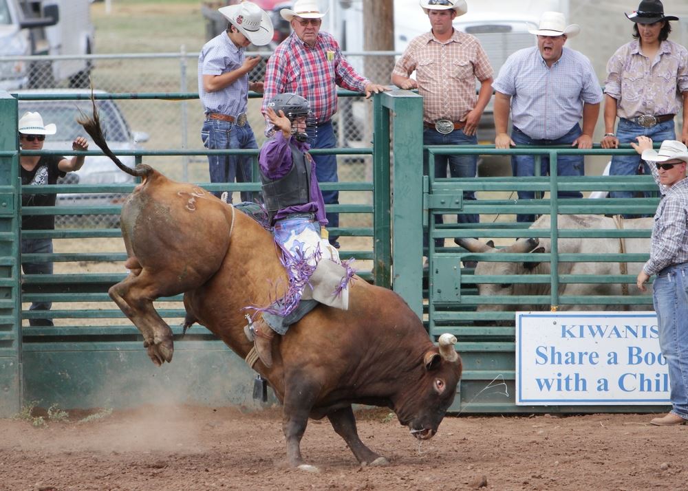 A man rides a bucking bull at the 2014 Klickitat County Fair Rodeo.