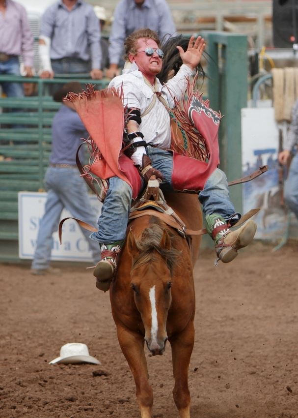 A man rides a bucking horse at the 2014 Klickitat County Fair Rodeo.