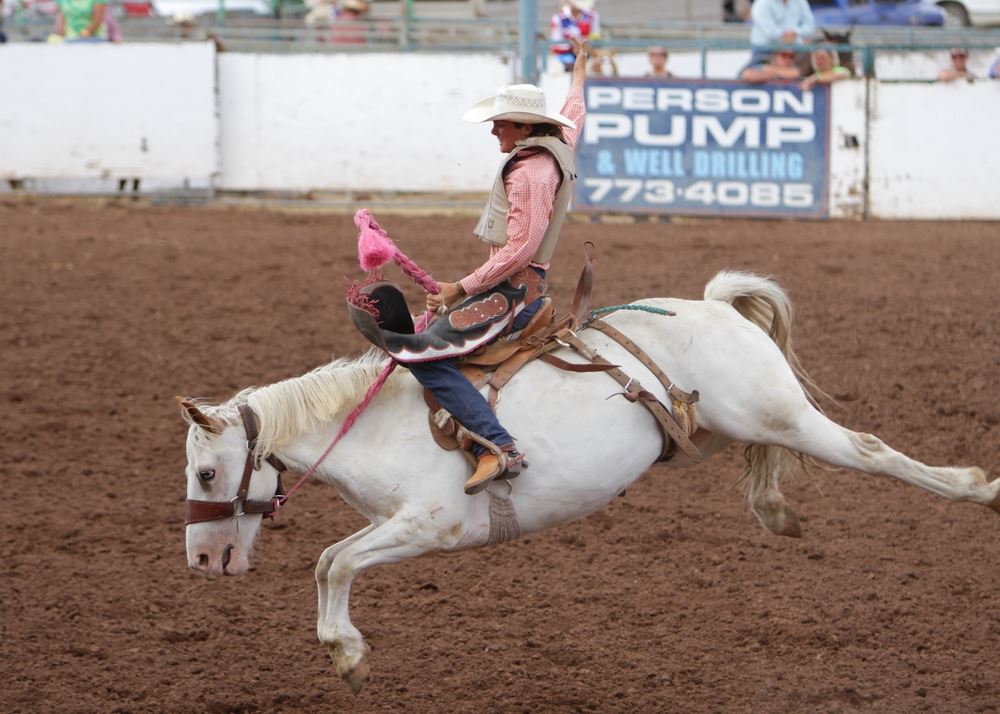 A woman holds tight as he horse bucks at the 2014 Klickitat County Fair Rodeo.