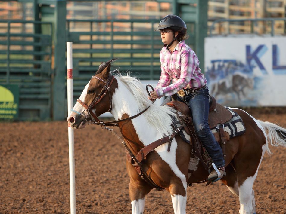 A young woman runs her horse around a pole at the 2015 Klickitat County Fair.