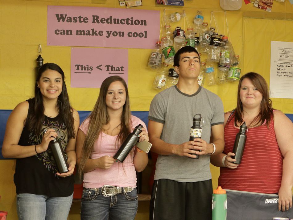Teens pose with their reusable water bottles at the Waste Reduction exhibit.