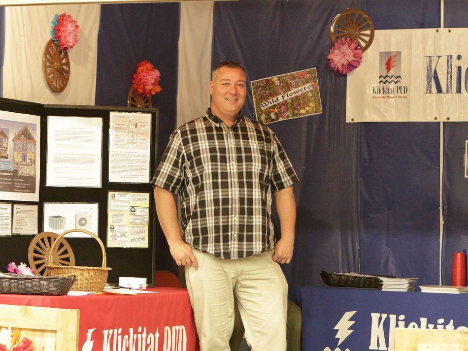 Man stands at a booth at the Klickitat County Fair.