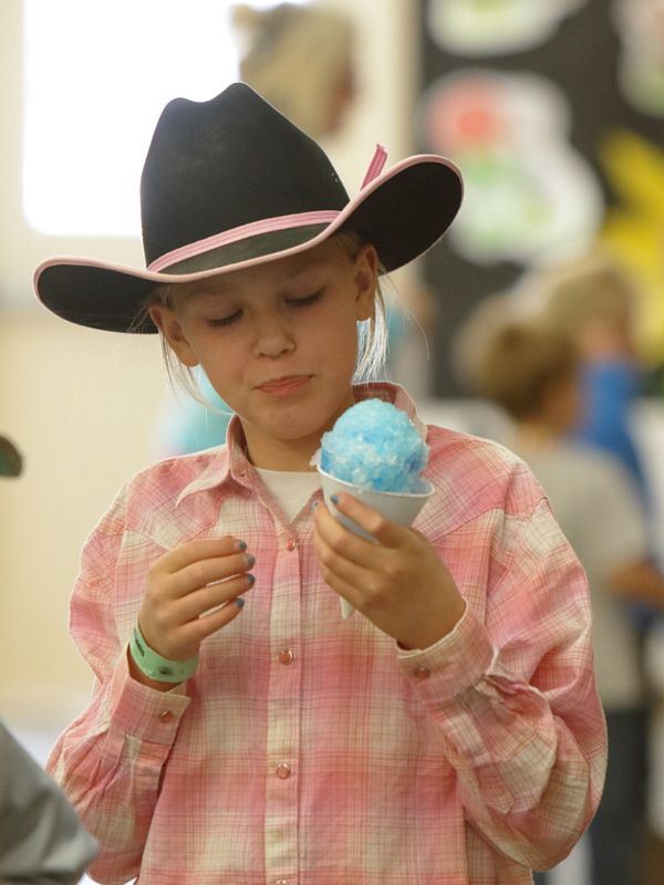 A girl eats a blue snow cone at the 2015 Klickitat County Fair.