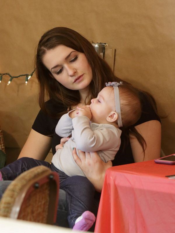 A young woman holds a baby girl at the 2015 Klickitat County Fair.