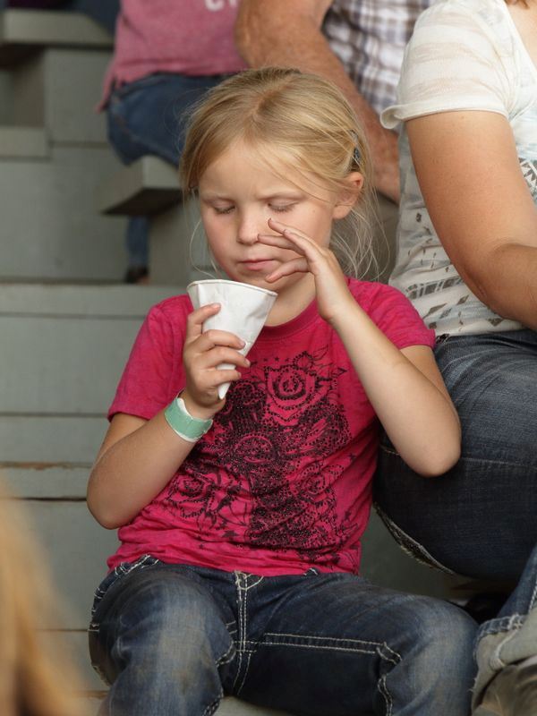 A little girl eats a snow cone at the 2015 Klickitat County Fair.