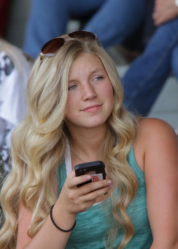 A girl holding her cell phone at the 2015 Klickitat County Fair.