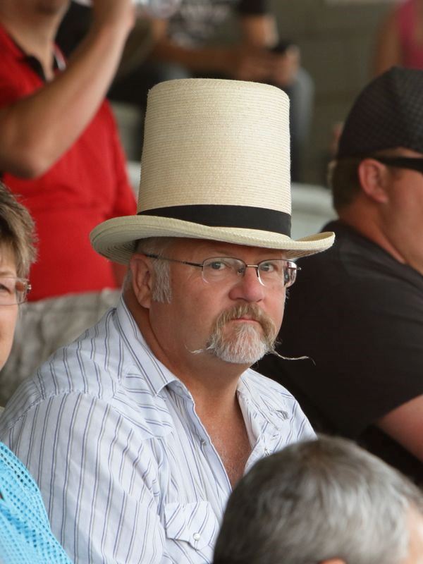 A man with a top hat and fancy mustache sits in the crowd at the 2015 Klickitat County Fair.